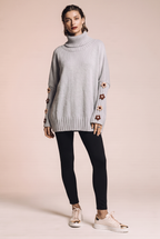 Dzianinowy sweter oversize z kwiatowymi naszyciami na rękawach