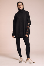 Dzianinowy sweter oversize z kwiatowymi naszyciami na rękawach