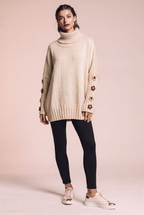 Dzianinowy sweter oversize z kwiatowymi naszyciami na rękawach
