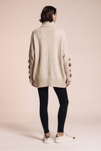 Dzianinowy sweter oversize z kwiatowymi naszyciami na rękawach